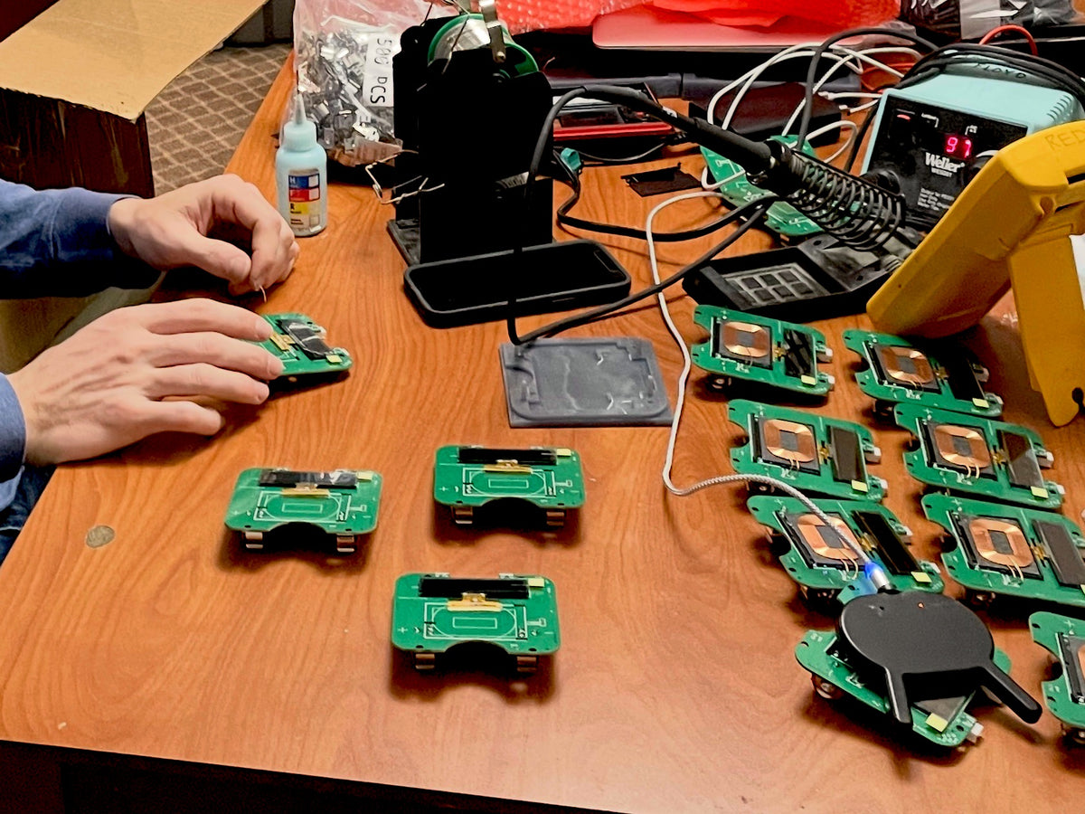 Conner Dickson assembling VOID lid circuit boards by hand at his workbench